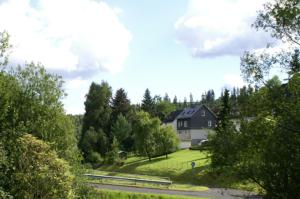 a house on a hill with a road and trees at Ferienwohnung Ilse und Eberhard Tröps in Siegen