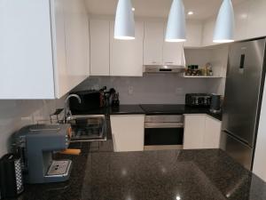 a kitchen with white cabinets and a mixer in it at 803 Bermudas - by Stay in Umhlanga in Durban