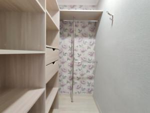 a walkin closet with a shower with a floral shower curtain at Apartament on Oktyabrskaya 132 in Bobruisk