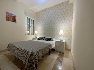 マドリードにあるEl Jardin del Angel Olmoのベッドルーム1室(ベッド1台、テーブルにランプ2つ付)
