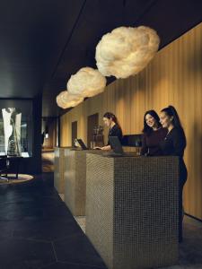 drie vrouwen aan een bureau met wolken aan de muur bij La Butte aux Bois in Lanaken