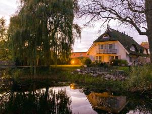 ミデルハーゲンにあるLandhaus am Teichの池のある家