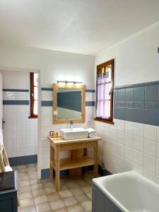 une salle de bains avec lavabo, miroir et baignoire dans l'établissement Hôtel Les Vieilles Tours Rocamadour, à Rocamadour