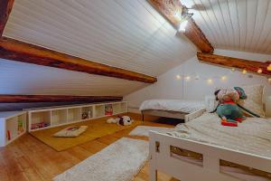 un dormitorio en el ático con 2 camas y un animal de peluche en L’Escarpin - Billard - centre historique en Romans-sur-Isère