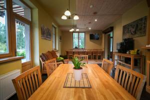 a dining room with a wooden table with a plant on it at LVM tūrisma un atpūtas centrs "Spāre" in Spāre