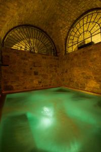 a swimming pool in a room with two windows at Eremito in Parrano