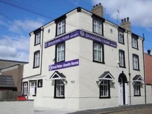 un edificio blanco con señales púrpuras en él en Brookfield Hotel, en Leeds