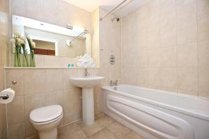 a bathroom with a toilet and a sink and a bath tub at Arcadian Aparthotel in Birmingham
