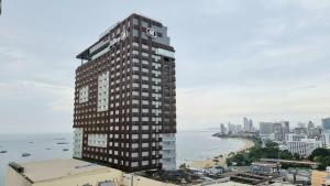 a tall building with a sign on it next to the ocean at View Talay 6 Pattaya Beach by CANDO in Pattaya Central