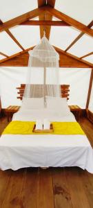 a bed in a room with a ceiling at Primitivo glamping buzios in Búzios