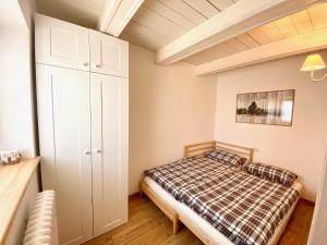 a bedroom with a bed and a white cabinet at Chalet Paoletta - Alpe Cermis in Cavalese
