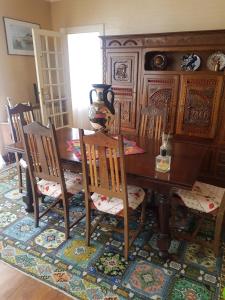 comedor con mesa de madera y sillas en Annick, en Hôpital-Camfrout