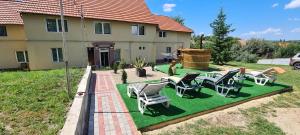 a yard with lawn chairs and a house at Pensiunea Baron Bazna in Bazna