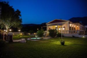 a house with lights in a yard at night at Moustakias Villa in Kefallonia