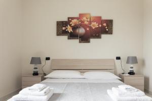a bedroom with a large bed with two towels at Residence La Perla in Stalettì