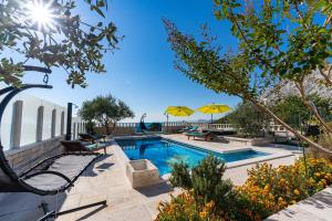 ŽrnovnicaにあるVilla Runjeの庭のプール(テーブル、パラソル付)