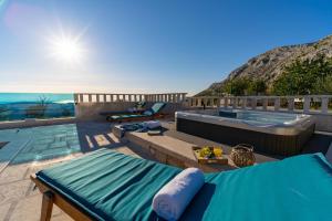 een patio met een zwembad en een hot tub bij Villa Runje in Žrnovnica +42 foto's