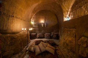 Höhlenzimmer mit einem Bett in einem Tunnel in der Unterkunft Eremito in Parrano