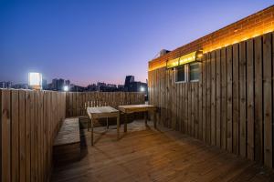 a wooden deck with a table and a bench on it at Hngstay in Seoul