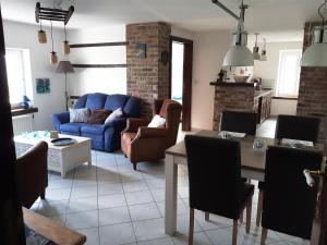 a living room with a blue couch and a table at (La parenthese) in Hombourg