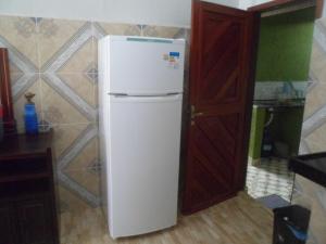 białą lodówkę w kuchni obok drzwi w obiekcie Lar Doce Mar w mieście Pipa