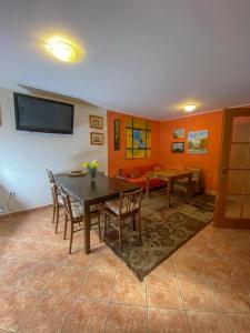 a dining room with a table and chairs and a tv at Chalupa - Sklep Starovice in Starovice