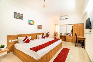 a bedroom with a bed and a desk and a television at Octave Paris Residency in Bangalore