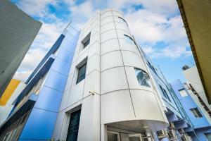 a white building with a blue sky in the background at Octave Paris Residency in Bengaluru
