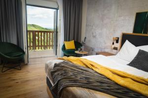 Habitación de hotel con cama y balcón en 111 Weinkitz en Kitzeck im Sausal