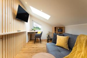 a living room with a blue couch and a desk at Das Weinkitz in Kitzeck im Sausal