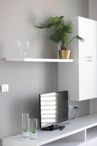 a computer monitor sitting on a desk with two glasses at The Residence Galliate in Galliate