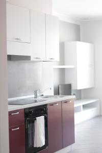 a kitchen with white cabinets and a black dishwasher at The Residence Galliate in Galliate