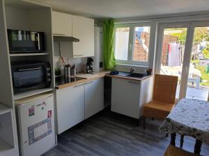 a kitchen with white cabinets and a table and a window at Studio Marmotte quartier marais, terrasse en rez de jardin in Bourges
