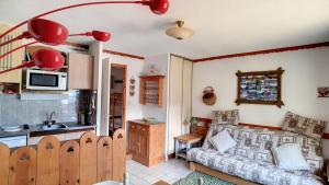 a kitchen and a living room with a couch at APPARTEMENT AU PIED DES PISTES - SAINT JEAN D'AULPS STATION - 6 Personnes - SCHUSS 10 in Saint-Jean-d'Aulps