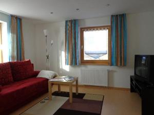 a living room with a red couch and a tv at Wohlfühl-Ferienwohnung Sonja in Bodenmais