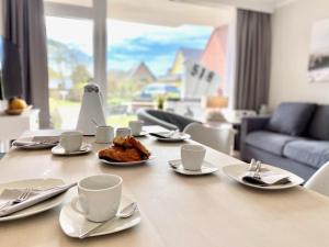 a table with coffee cups and pastries on it at Großes Mollymook in Wenningstedt