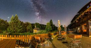 a patio with tables and chairs under the milky way at Zum Wilden Michel in Oberlinach