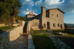 an old stone building with a stone wall at Eremito in Parrano