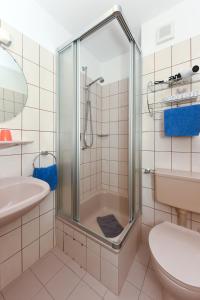 a bathroom with a shower and a toilet and a sink at Hotel-Pension Störtebeker in Bensersiel