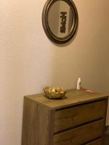 Braun Residence في ساتشيلي: مرآة على جدار مع وعاء على طاولة خشبية