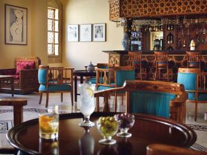 ein Esszimmer mit Tischen und Stühlen und eine Bar in der Unterkunft Mövenpick Resort Petra in Wadi Musa