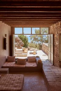 a living room with a couch and a large window at Nature Eco Living Serifos in Livadion