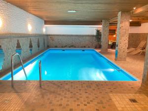 a large swimming pool in a room with a tile floor at Burghotel Nürnberg in Nürnberg