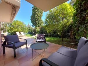 een patio met 2 stoelen en een tafel bij Plage la Salis 3 chambres, Jardin - 3 bedrooms in Antibes
