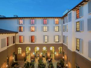 un grande edificio con persone sedute nel cortile di 25hours Hotel Florence Piazza San Paolino a Firenze