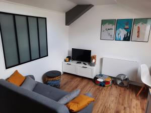 a living room with a blue couch and a tv at Superbe appartement pour 2, au cœur de l'Ariège! in Ussat