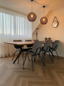 ein Esszimmer mit einem Tisch und Stühlen in der Unterkunft De Vrije wil in Buren
