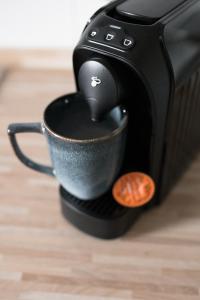een koffiezetapparaat is het maken van een kopje koffie bij FachwerQ'sleep Apartment in Quedlinburg