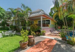 Cette maison jaune dispose d'une terrasse et d'une piscine. dans l'établissement Lemon House, à Patong Beach