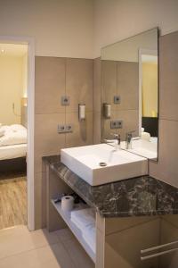 Lichtenau的住宿－Motel Lohwasser，一间带水槽和镜子的浴室以及一张床